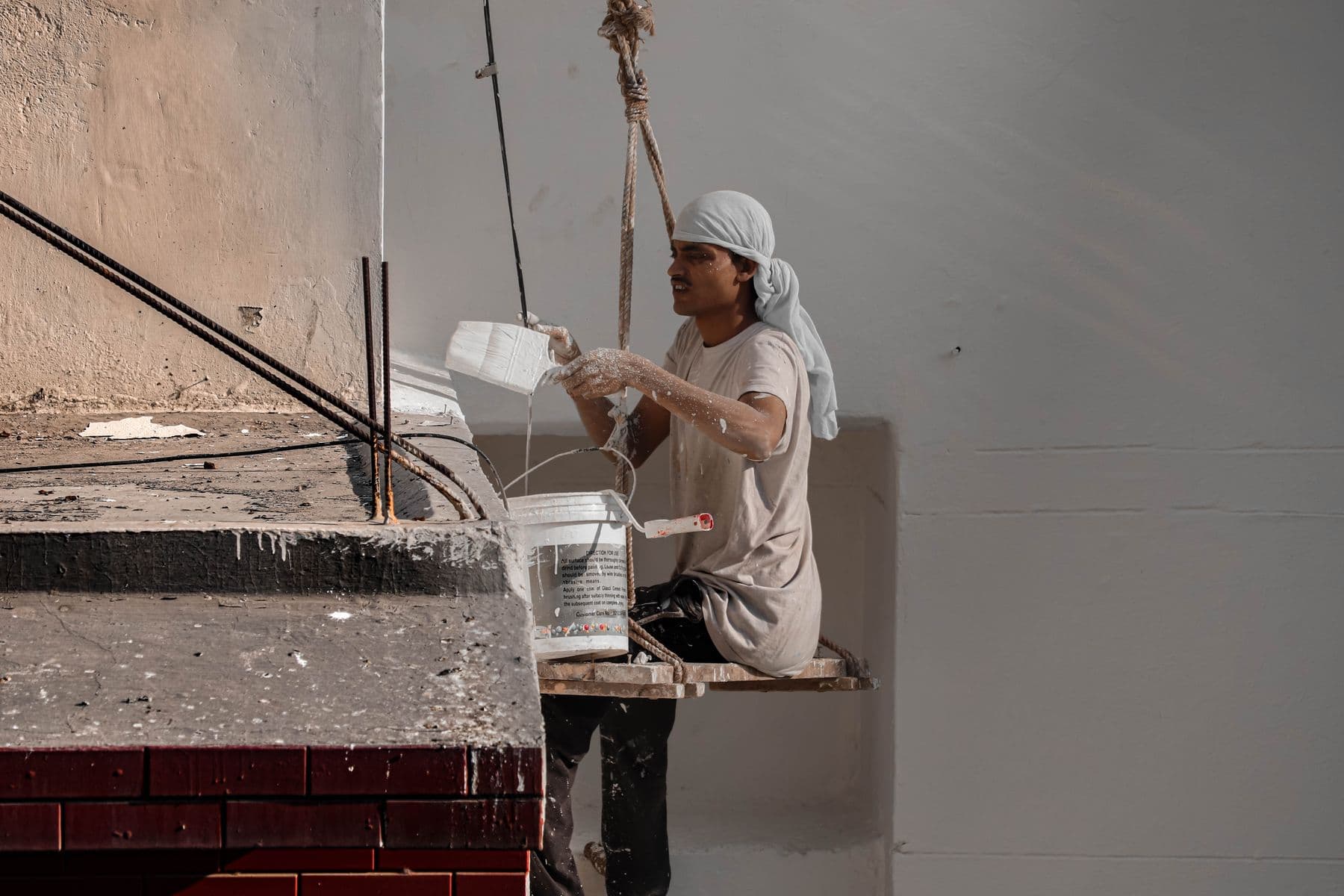 Painter on scaffolding painting an exterior wall